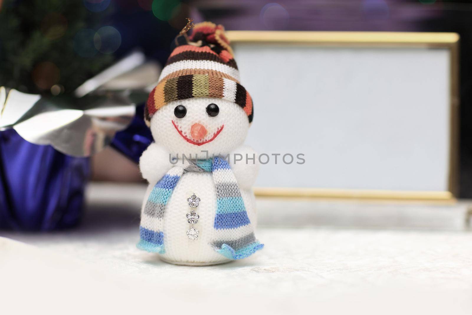fun toy snowman in knit hat and scarf and blank Christmas backgr by SmartPhotoLab