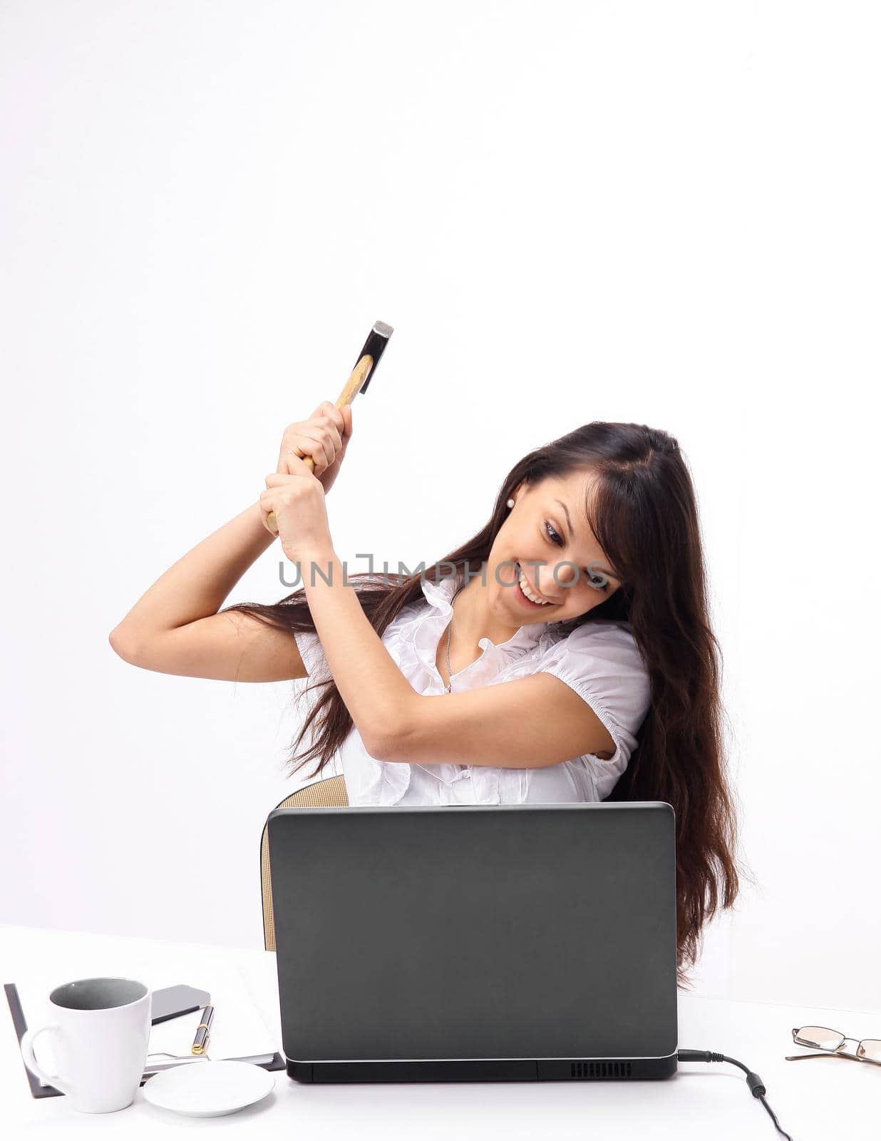 young business woman smashing a laptop sitting behind a Desk. by SmartPhotoLab