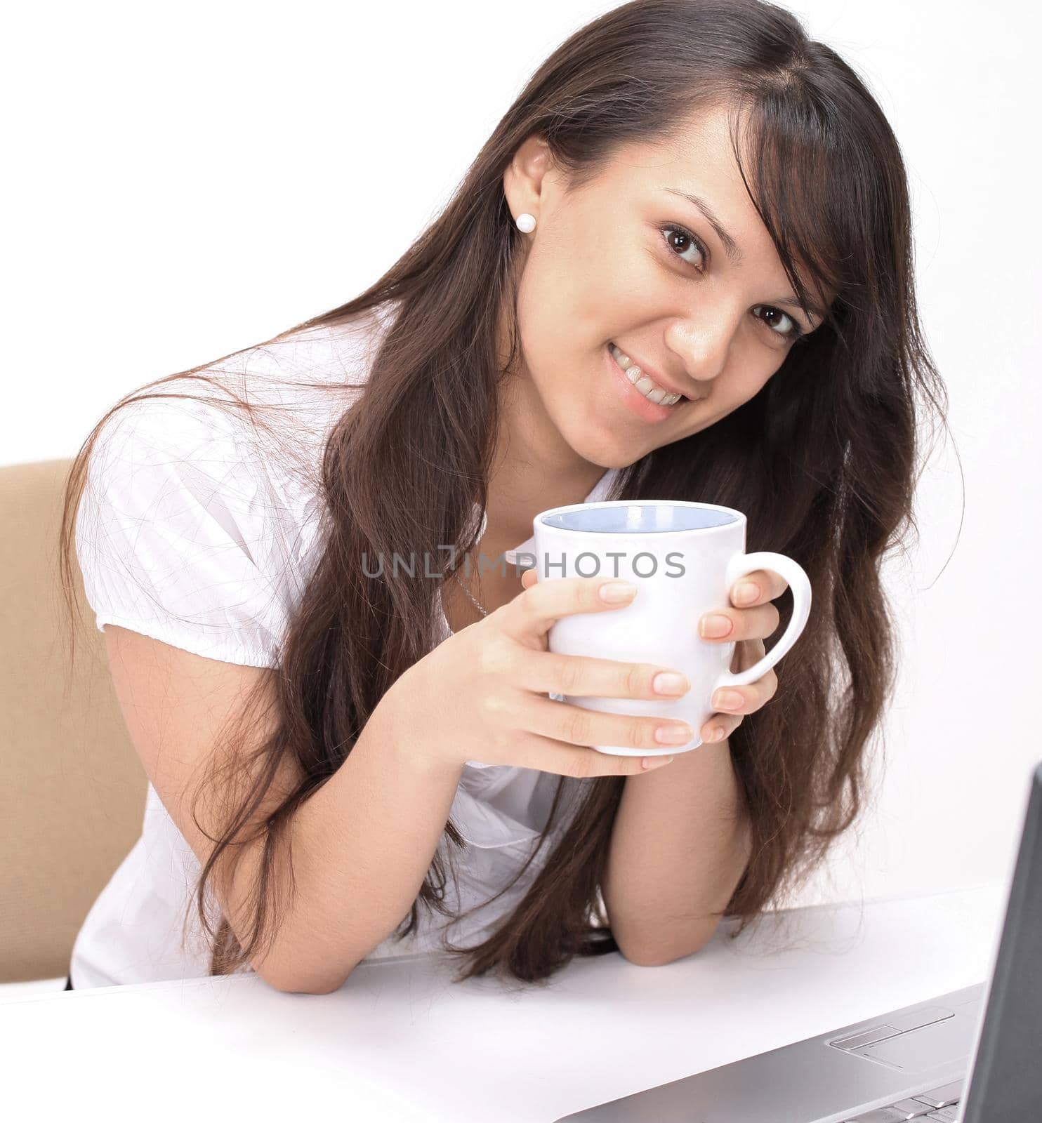 young woman with Cup of tea sitting in the workplace by SmartPhotoLab