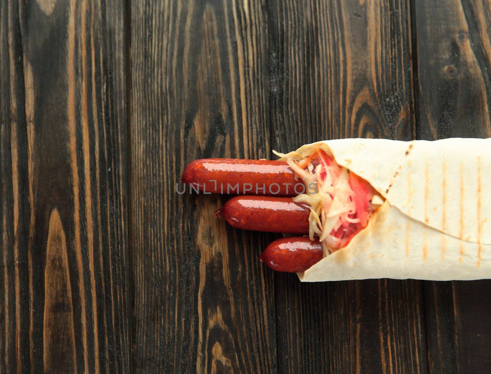 spicy sausages in pita bread on wooden background.photo with copy space by SmartPhotoLab