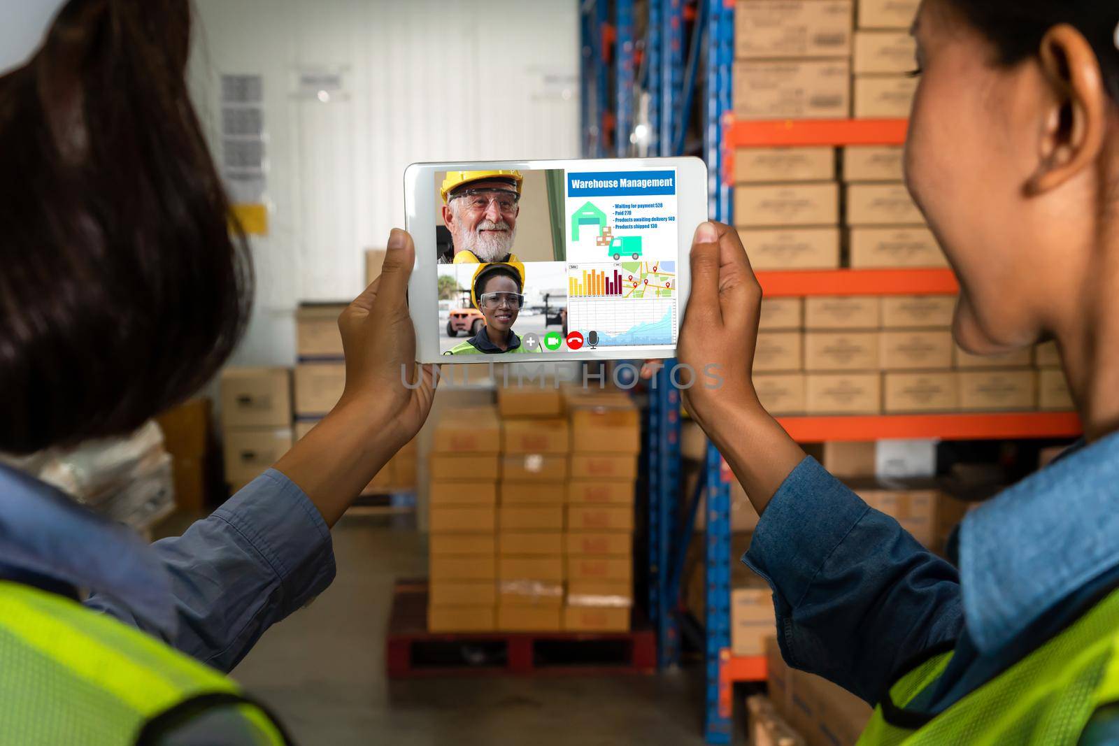 Warehouse staff talking on video call at computer screen in storage warehouse by biancoblue