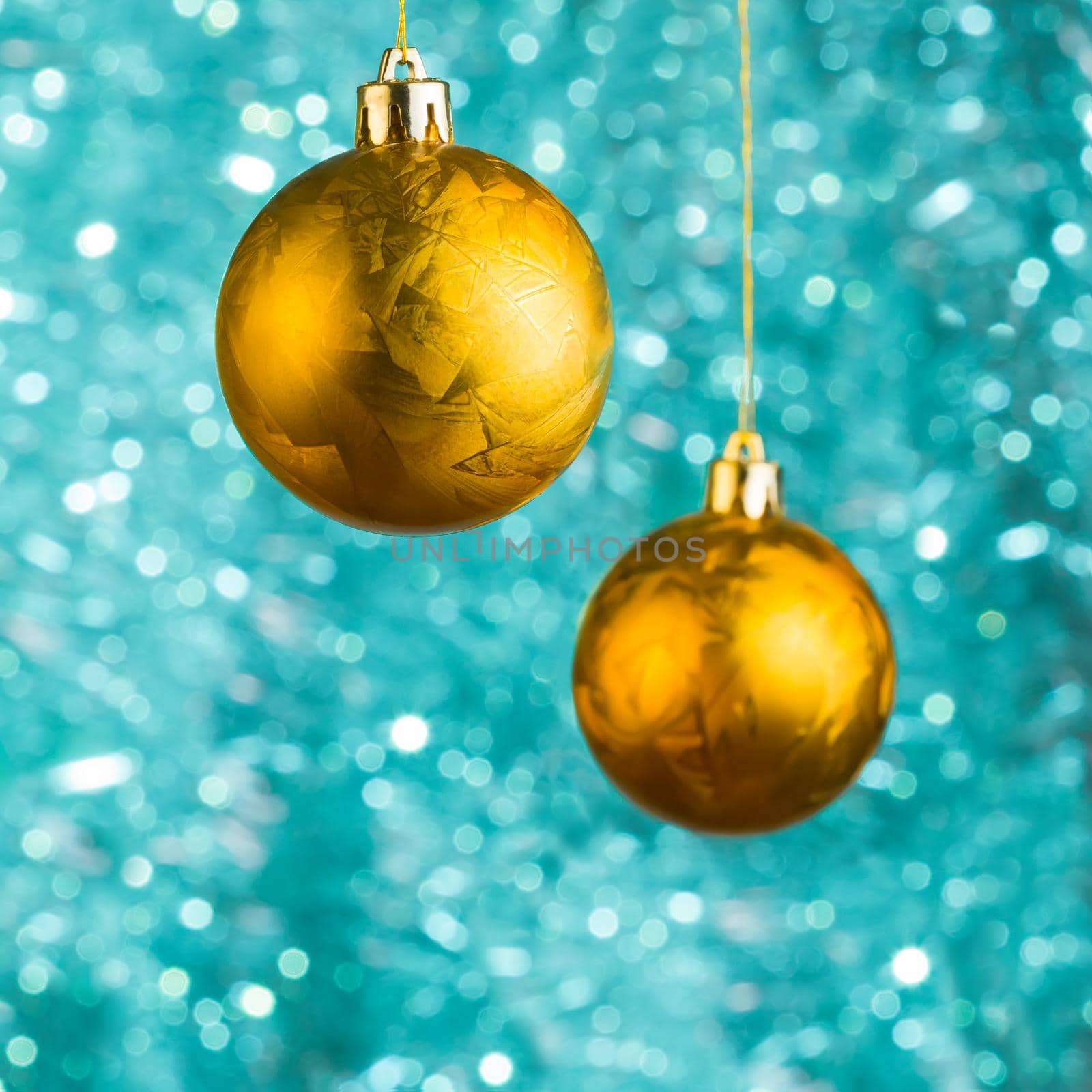 Golden Ð¡hristmas balls over blue bokeh background with copy-space