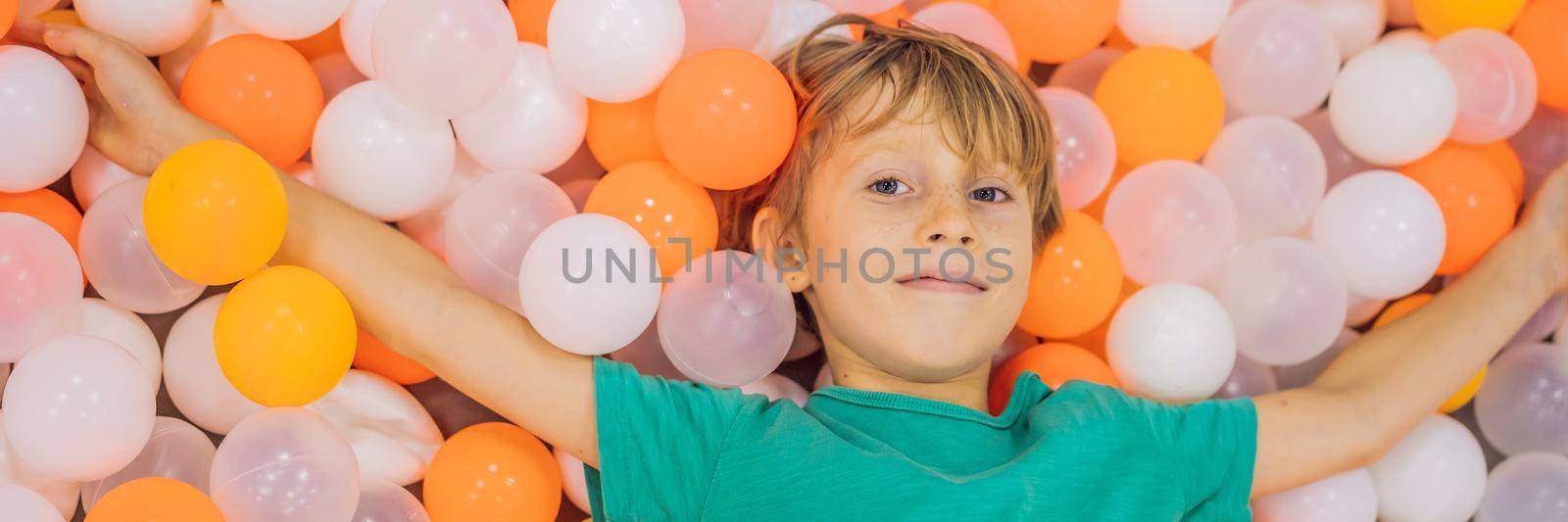 Child playing in ball pit. Colorful toys for kids. Kindergarten or preschool play room. Toddler kid at day care indoor playground. Balls pool for children. Birthday party for active preschooler. BANNER, LONG FORMAT