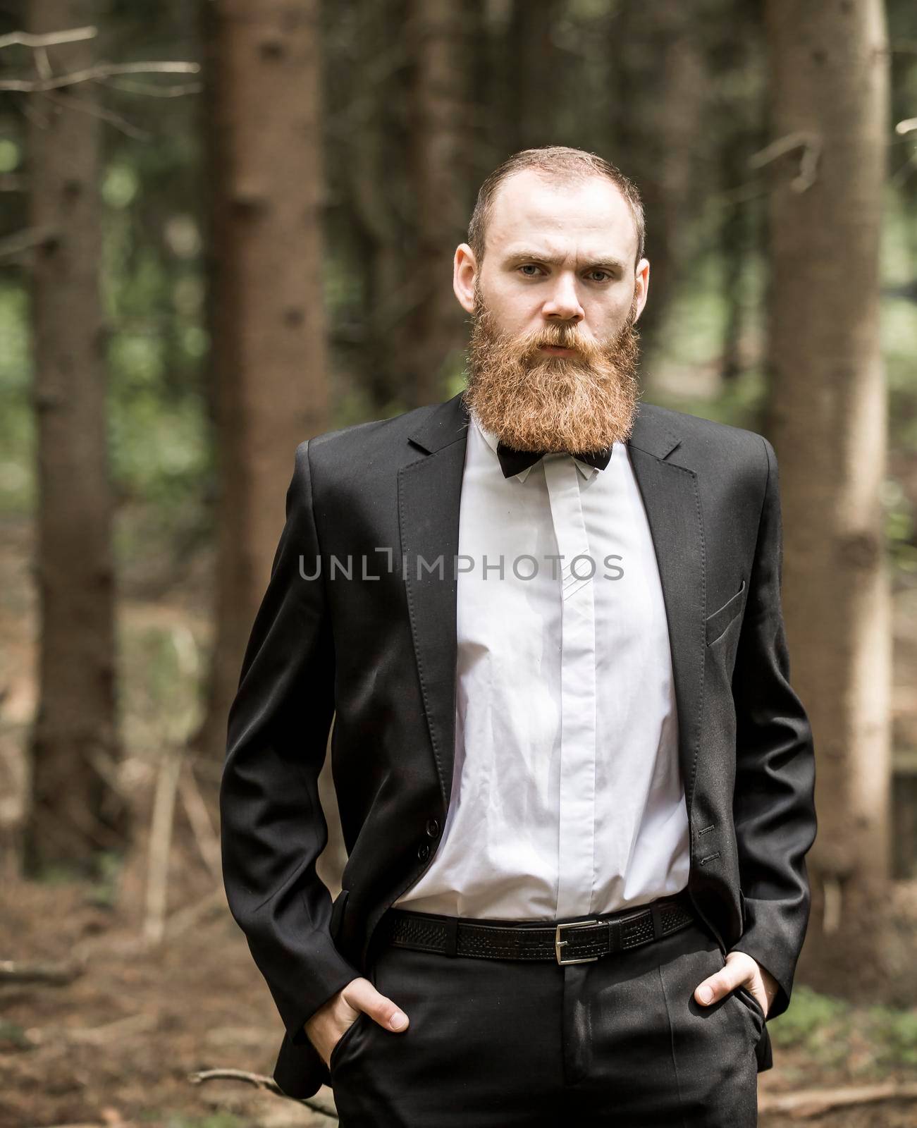 successful man in a business suit in a forest. by SmartPhotoLab