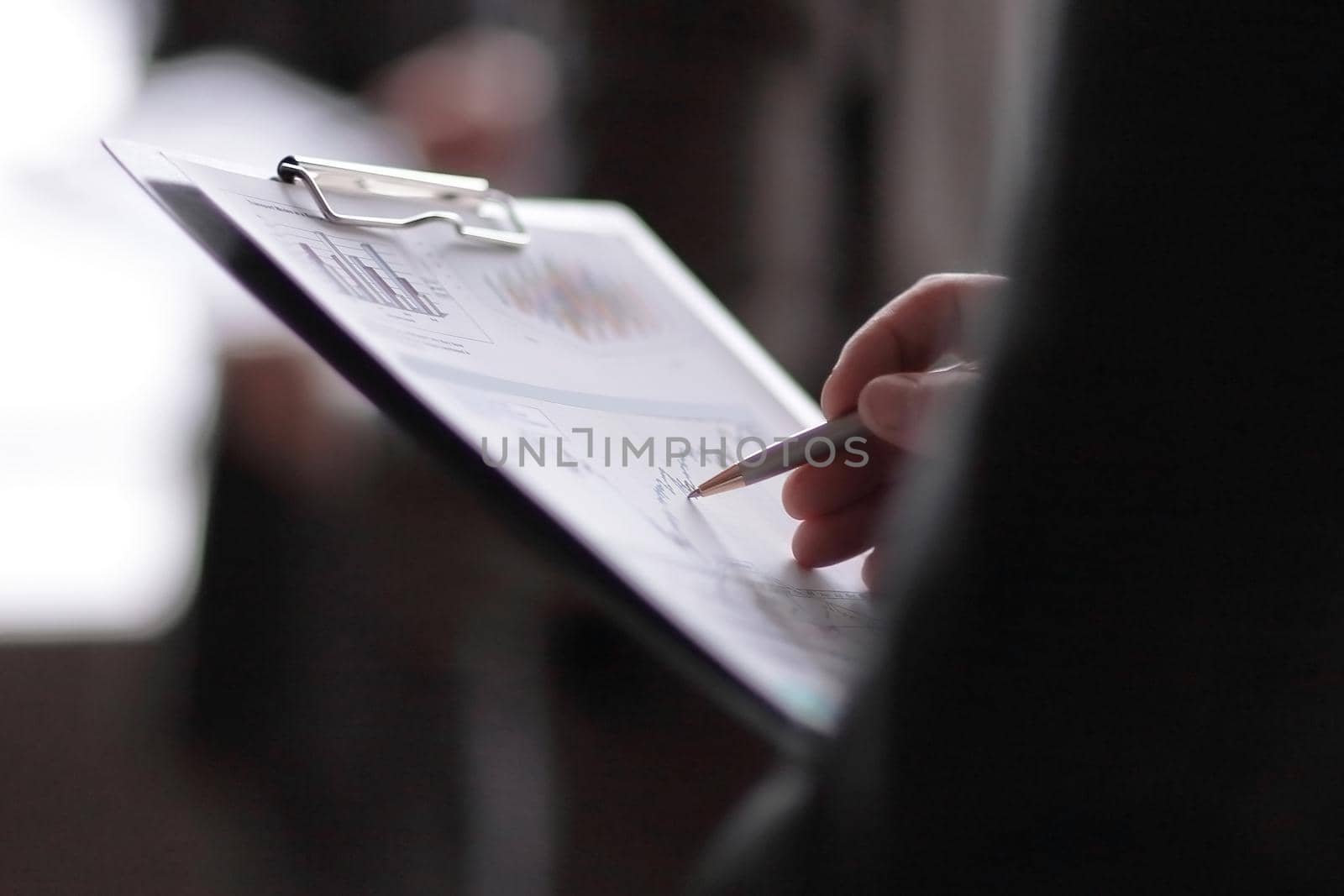 close up.businessman with a clipboard on the background of colleagues.