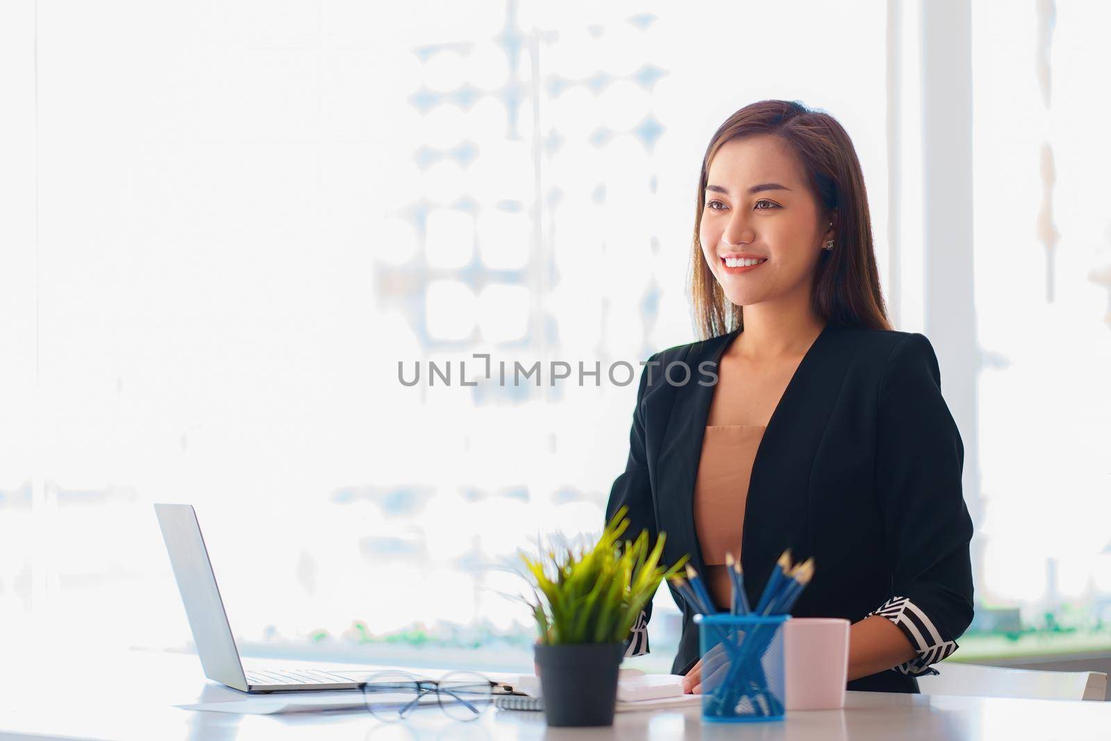 A portrait of Asian happy Businesswoman smiling and working at office