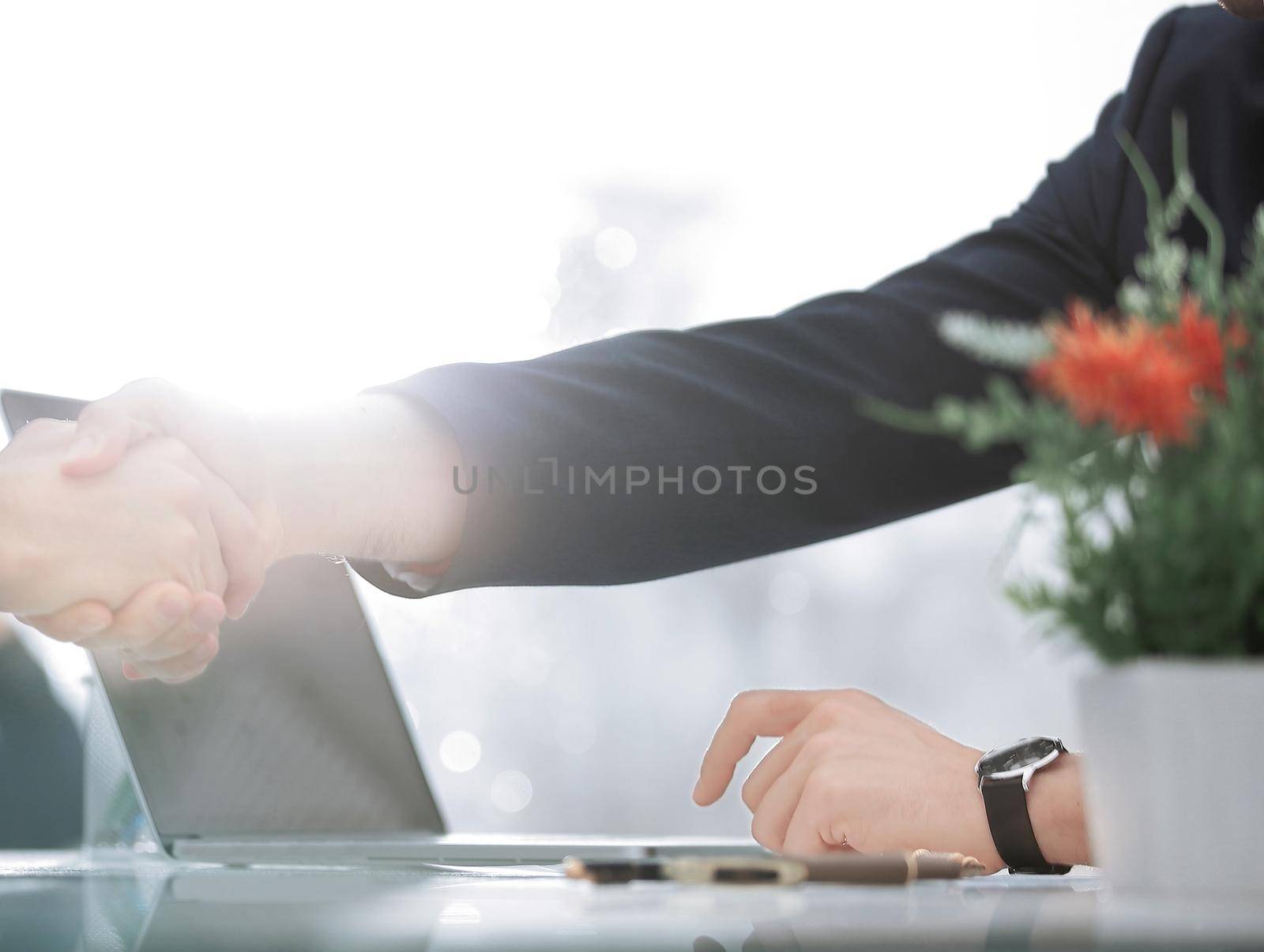 close up.the background image of a handshake over the Desk by SmartPhotoLab