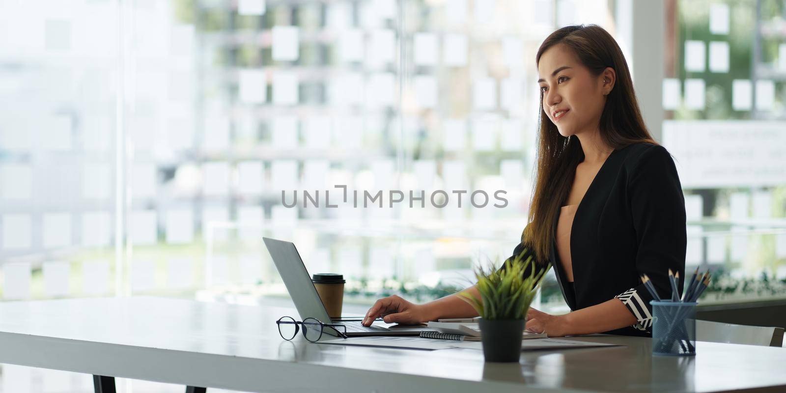 A portrait of Asian happy Businesswoman smiling and working at office