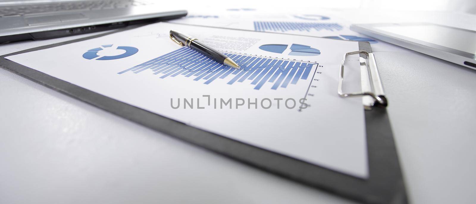 close up.clipboard with the financial report on the desktop. by SmartPhotoLab