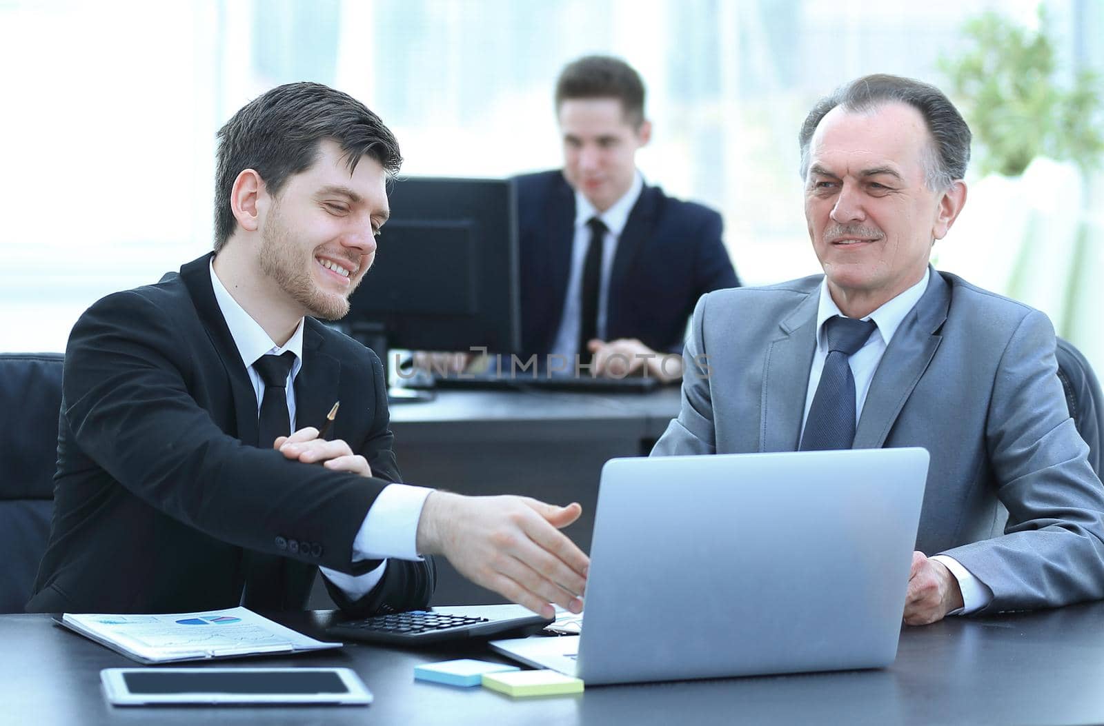 smiling employees working with financial documents in the office