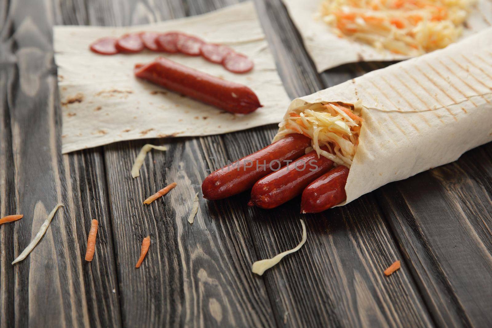 smoked sausage in pita bread on wooden background by SmartPhotoLab