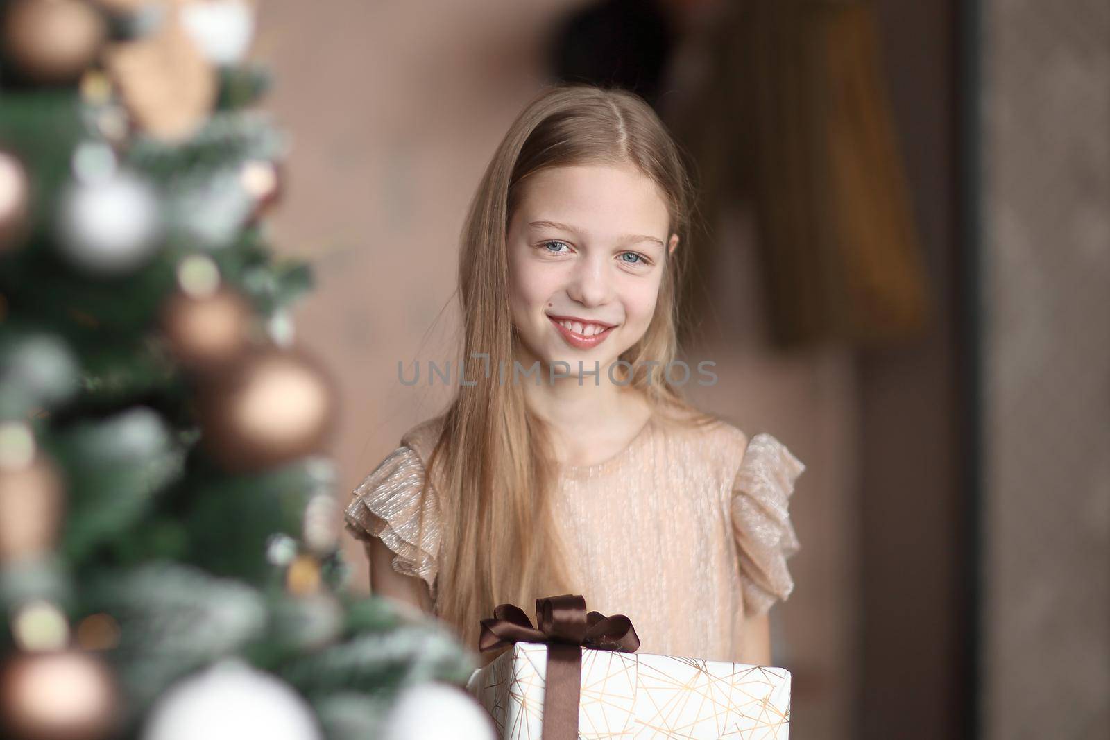 happy girl with Christmas gift standing near Christmas tree . holiday concept