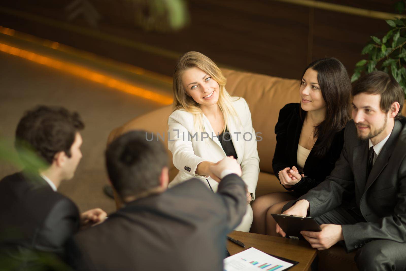 A diverse attractive man and woman business team handshake at office building by SmartPhotoLab