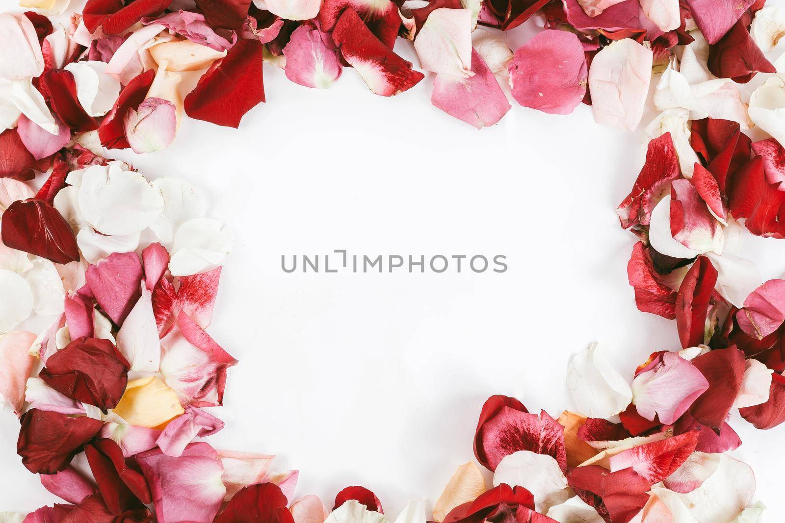 box with ring and rose petal frame on wooden background. photo with copy space