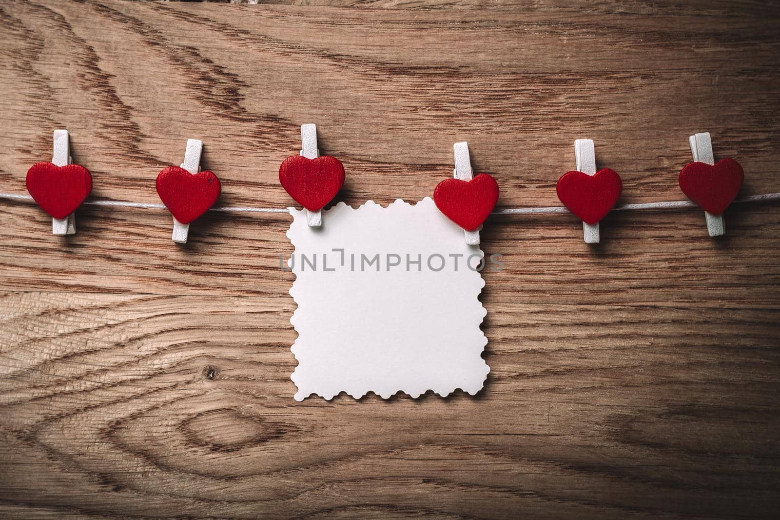 hearts and blank note on the clothespin on wooden background. by SmartPhotoLab