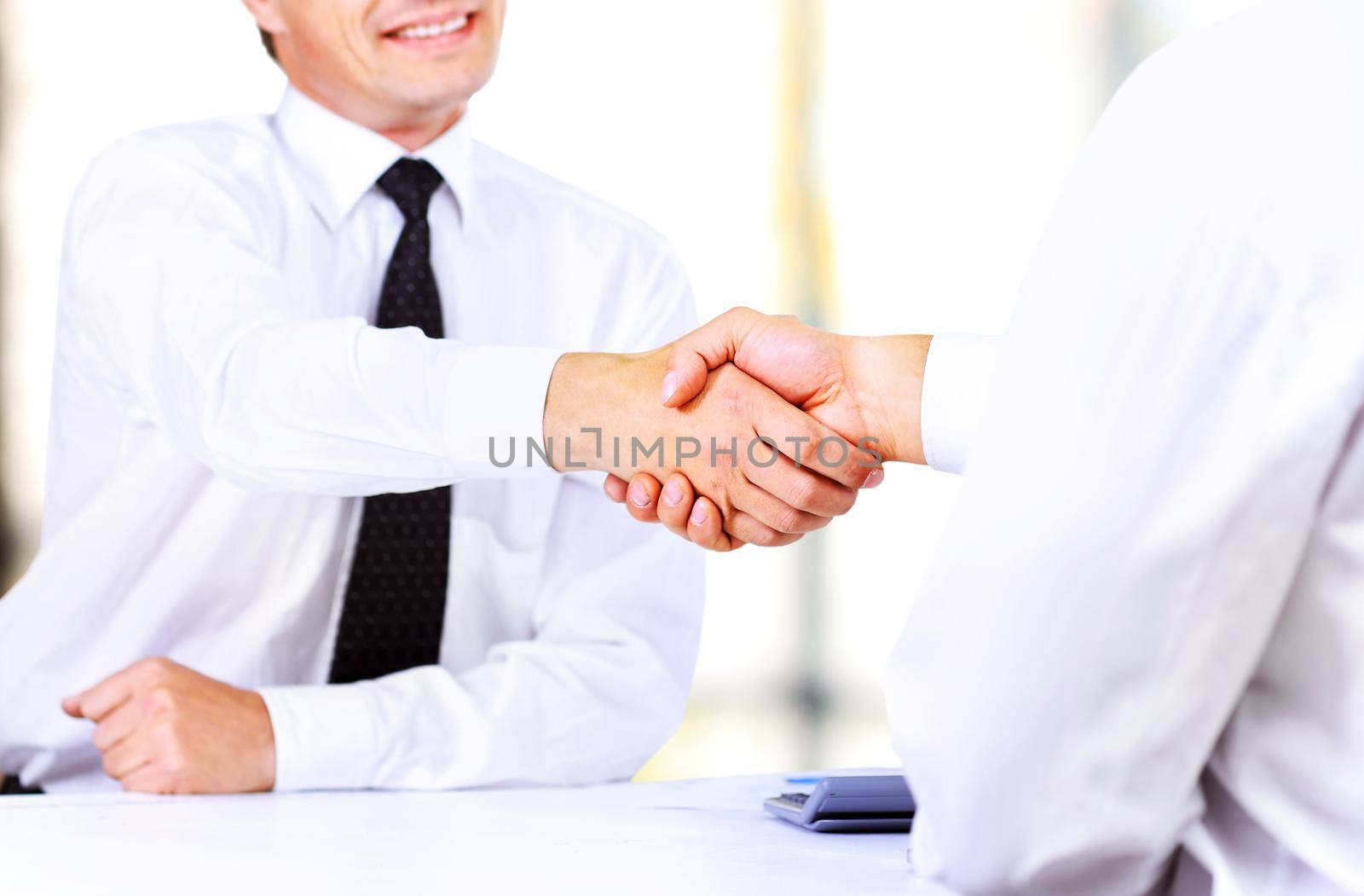 Close up image of business handshake at meeting. Partnership concept by SmartPhotoLab