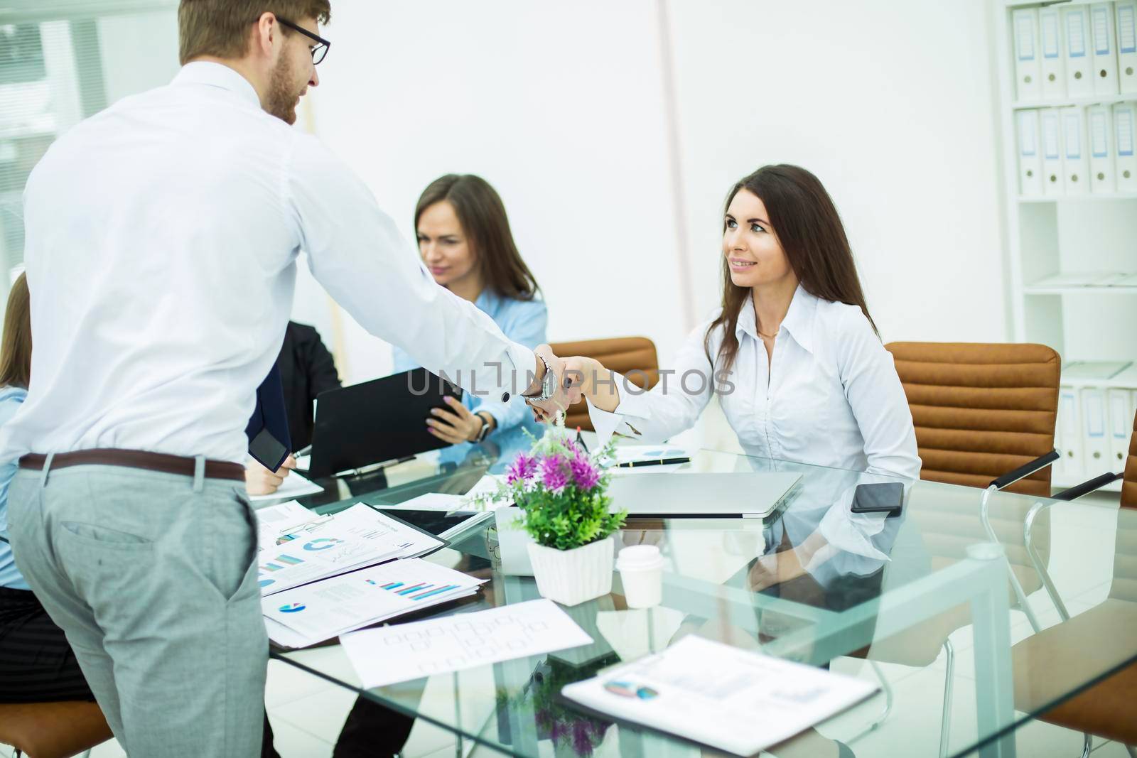 handshake with a senior Manager and a client at a business meeting in a modern office
