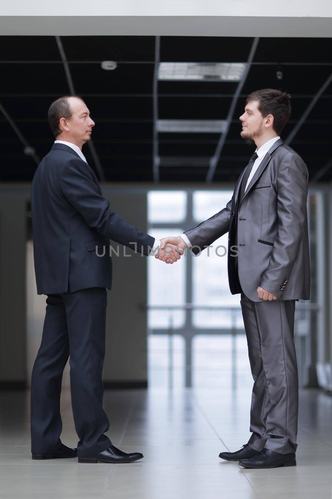 handshake of business partners in the corridor of the office by SmartPhotoLab