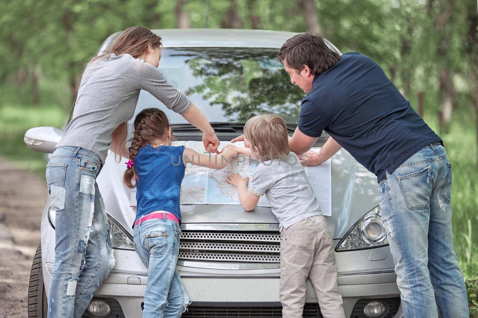 family with children standing near the faulty car . adventures on the road