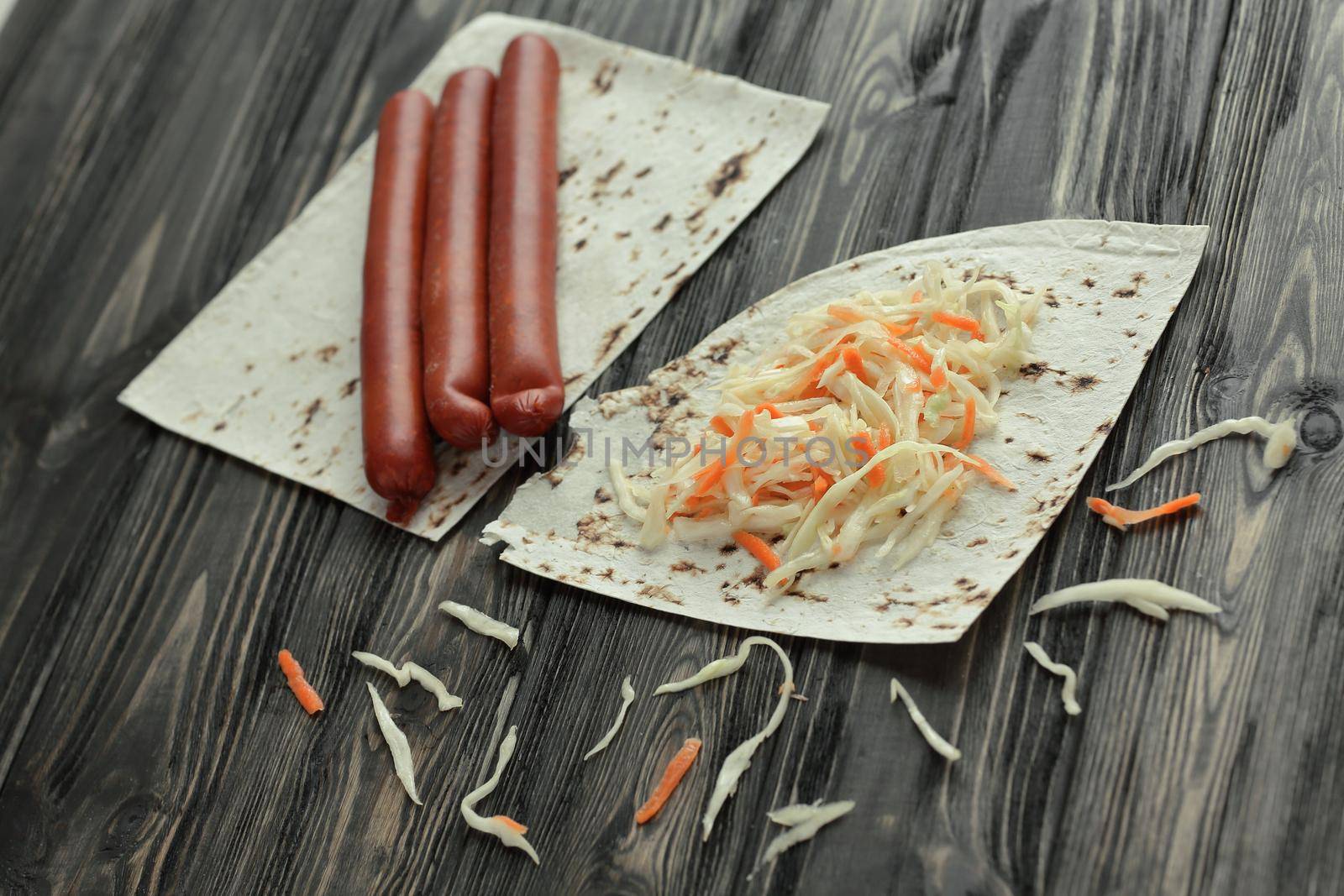 delicate sausages ,cabbage and pita bread on wooden background.