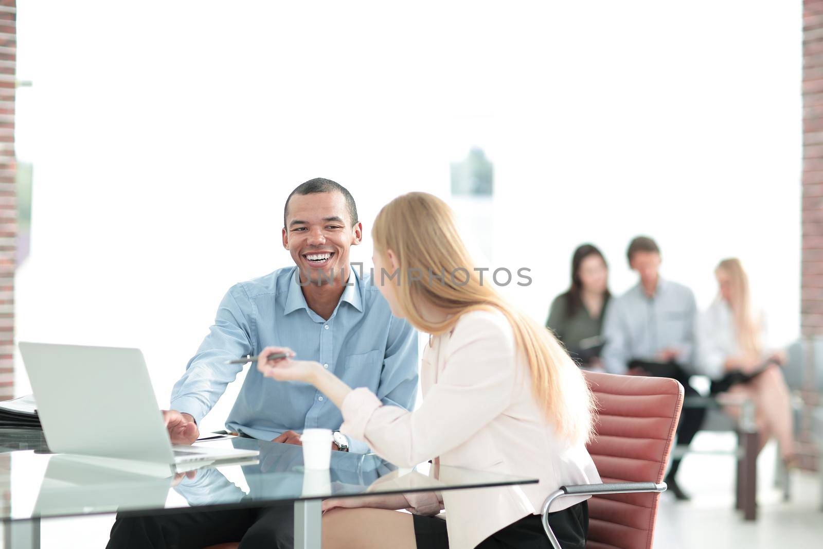 Beautiful young business partners are using a laptop, discussing documents.photo with copy space