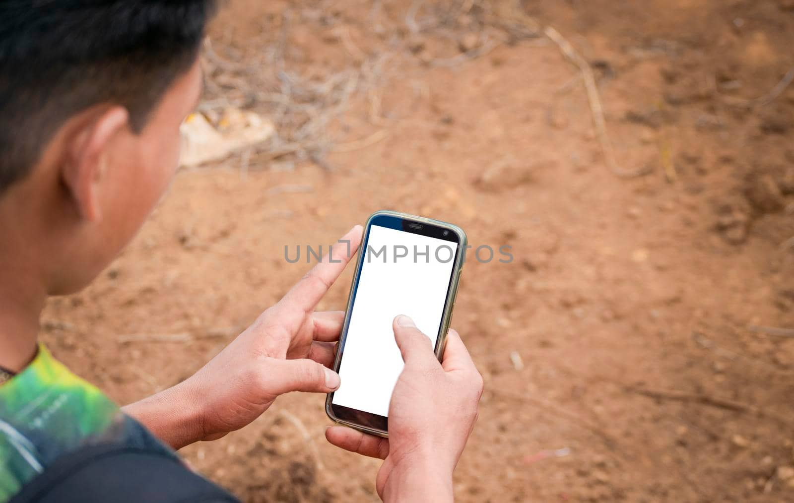 Close up of a man with cell phone in hand, close up of hands with cell phone with white screen, young guy with cell phone in hand with copy space
