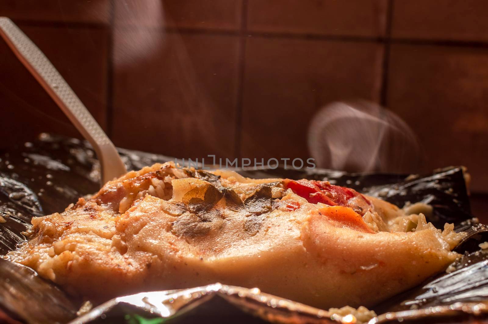 Nacatamal served in banana leaf, Close up of Nicaraguan nacatamal, Typical Nicaraguan food El nacatamal, Typical Nicaraguan food by isaiphoto