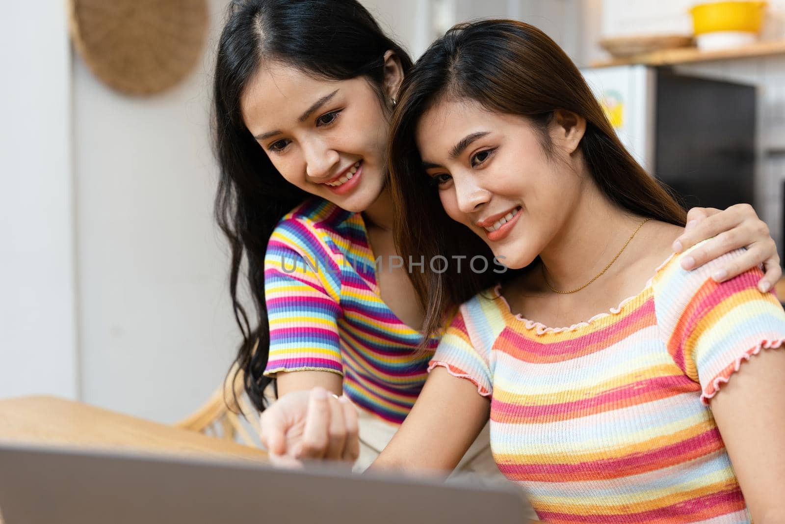 lgbtq, lgbt concept, homosexuality, portrait of two asian women posing happy together and loving each other while playing computer laptop by Manastrong