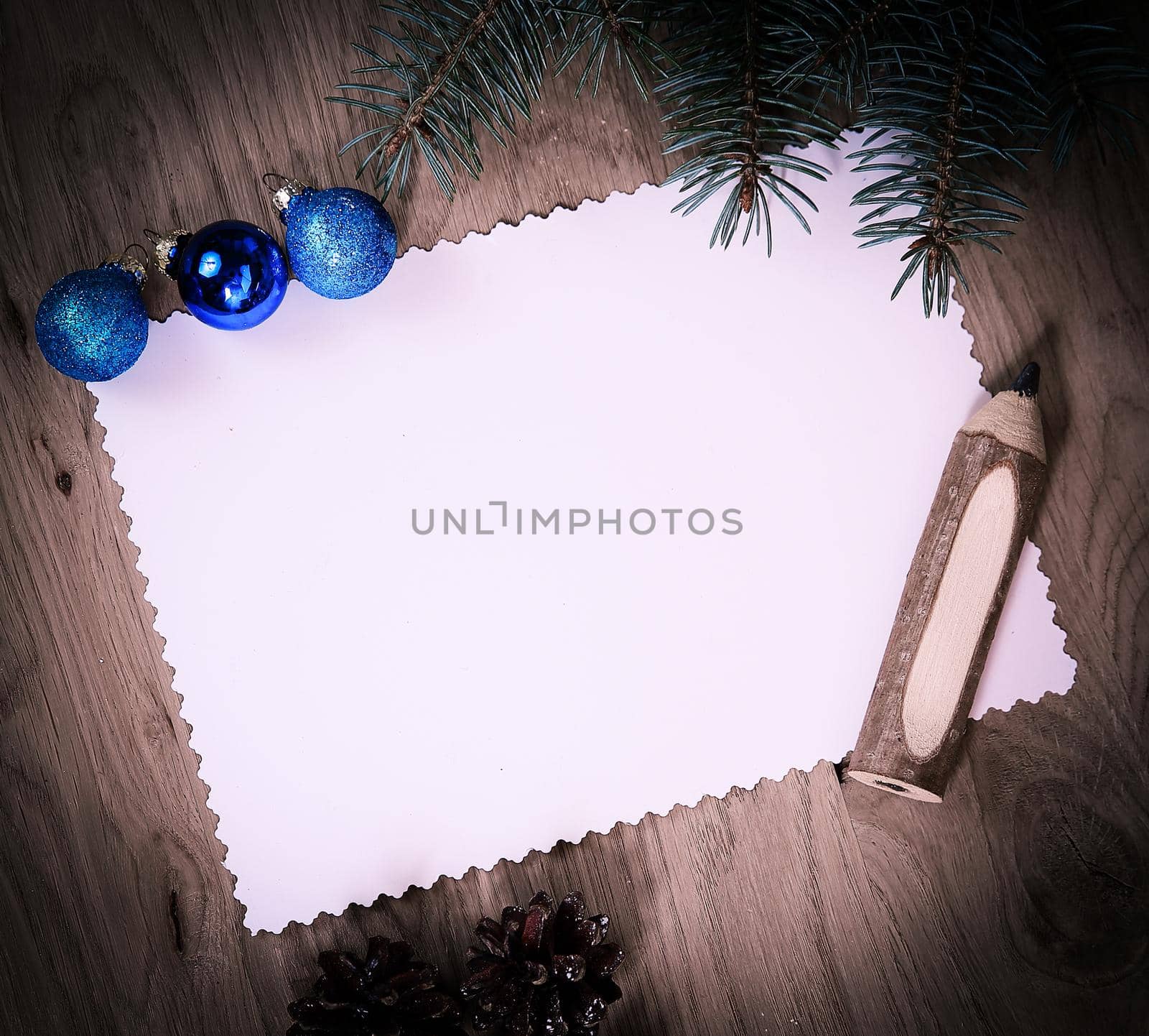 blank Christmas card ,pine cones and pencil on wooden background. place for text