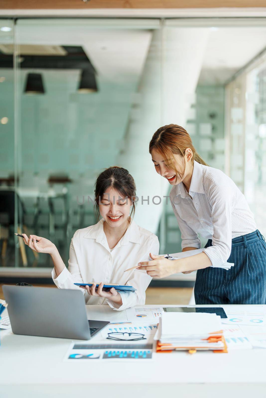 Negotiation, Analysis, Discussion: Portrait of an Asian woman economist and marketer pointing to a financial data sheet to plan investments to prevent risks and losses for the company.