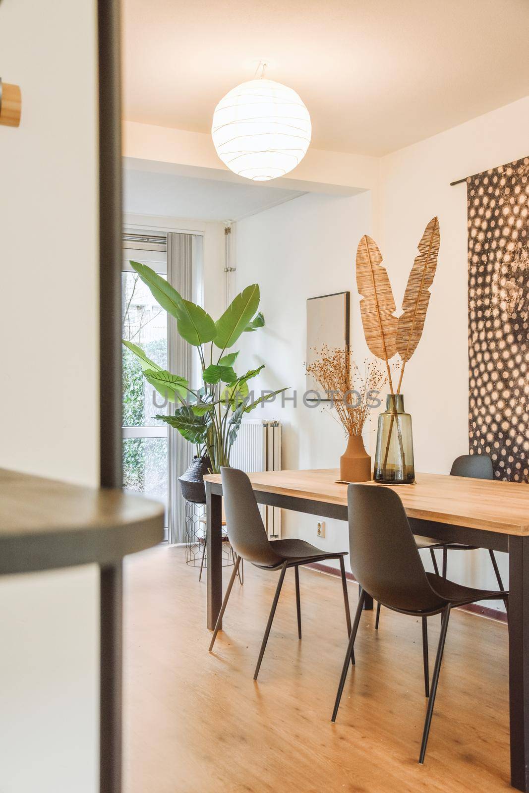 wooden black table with stylish chairs and plants in the sitting room