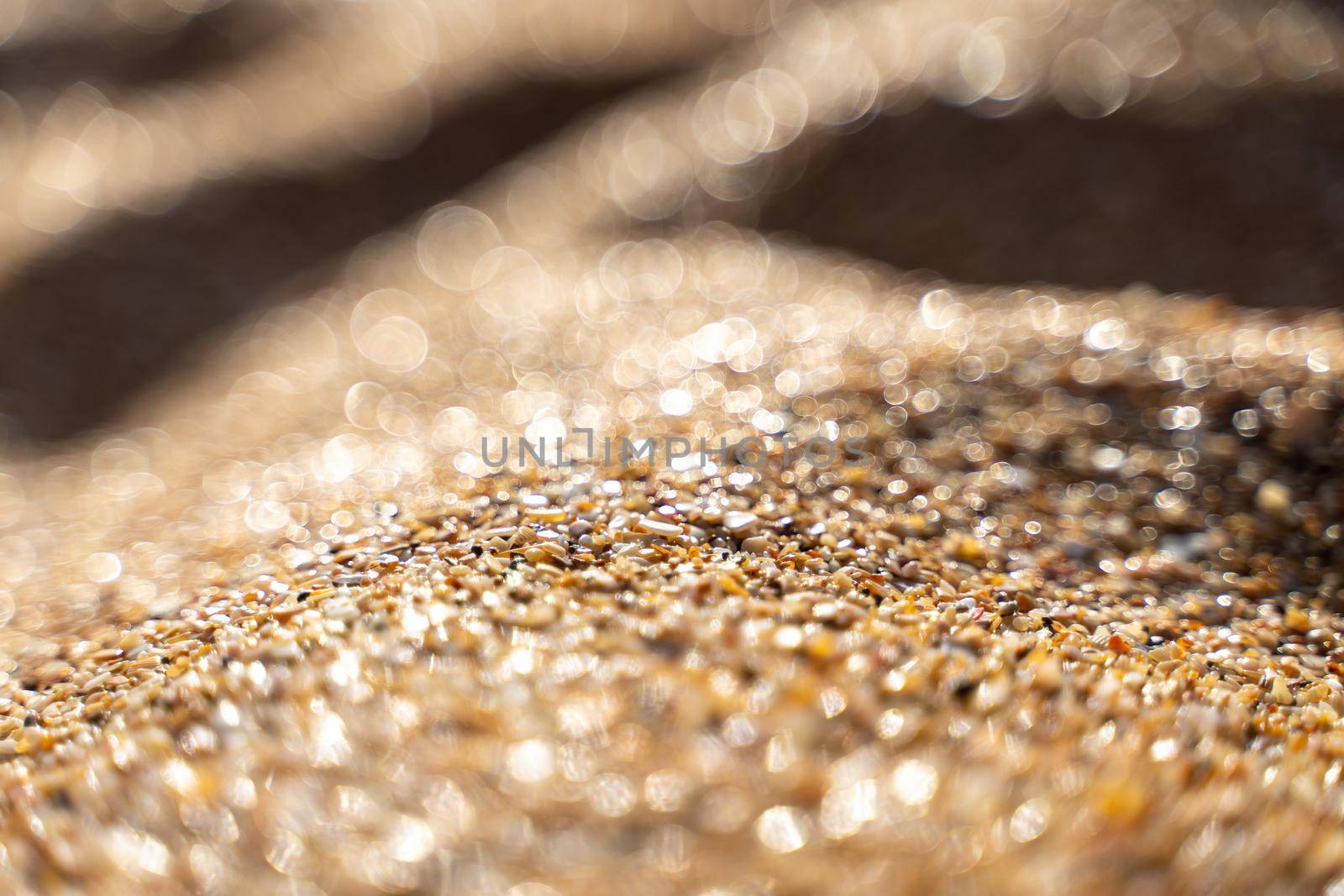 Golden sand on the coast at sunset with bokeh by Matiunina