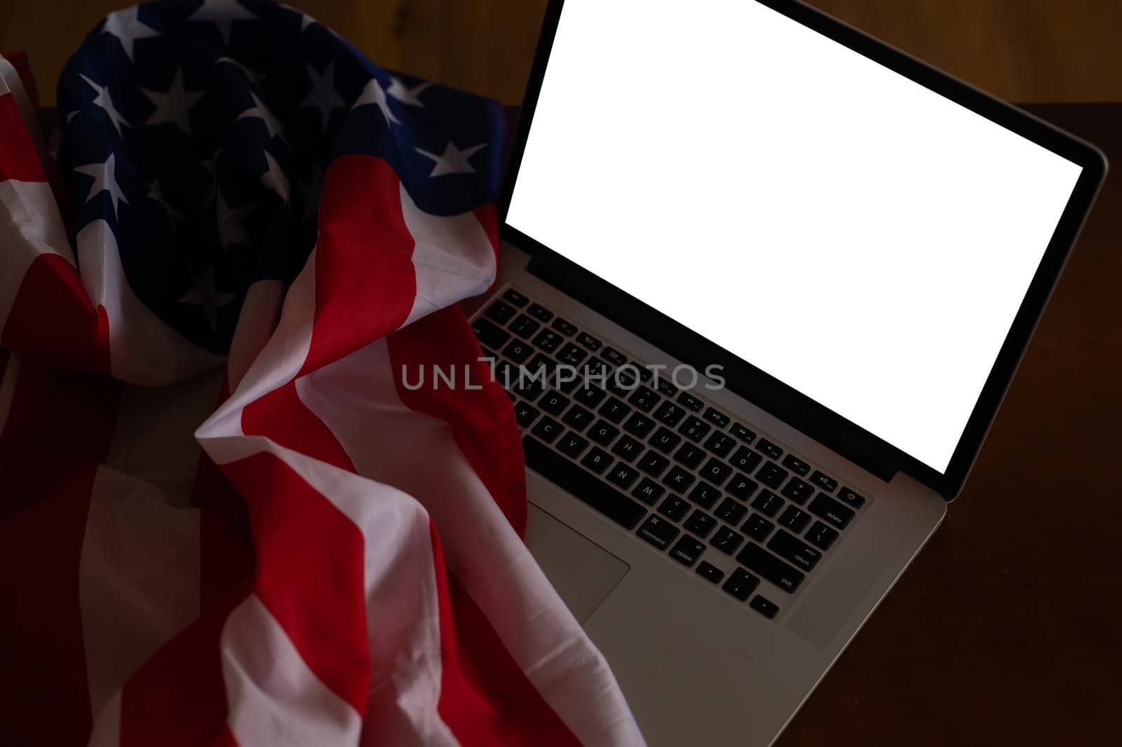 Laptop with blank screen and USA flag on desk in office by Andelov13