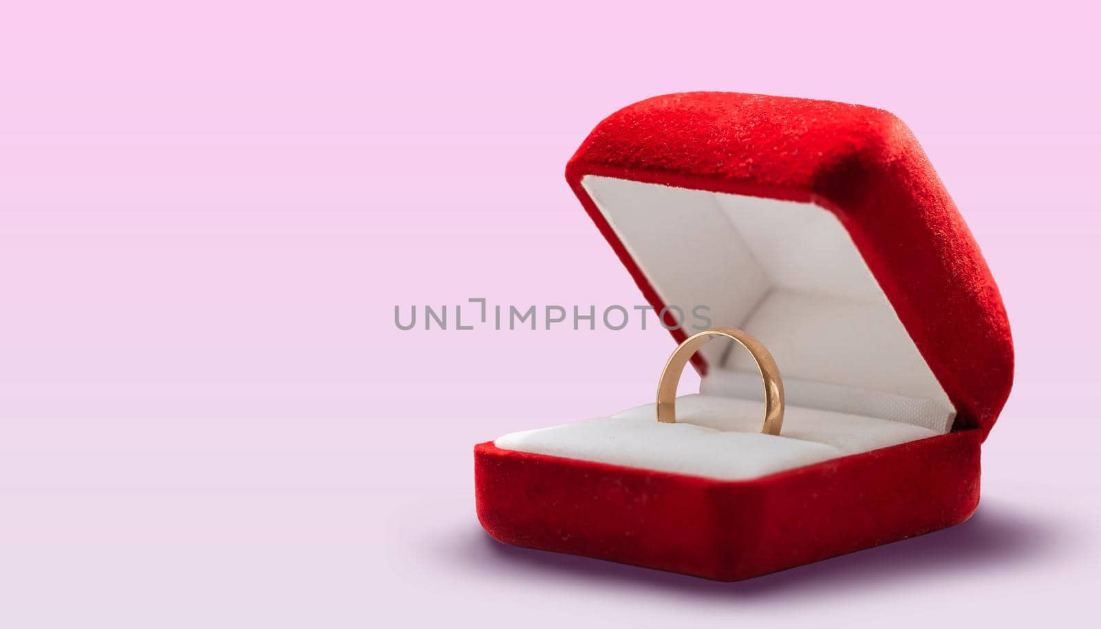 Gold ring, wedding ring in red box. The moment of a wedding, anniversary, engagement, or Valentine's Day. Happy day. by Andelov13