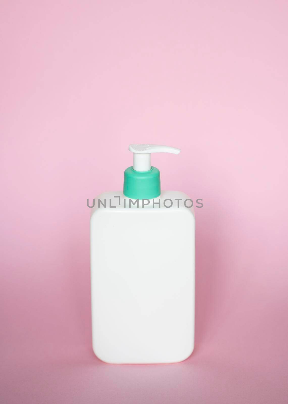 Large white plastic bottle with pump dispenser as a liquid container for gel, lotion, cream, shampoo, bath foam on pink background. by vovsht