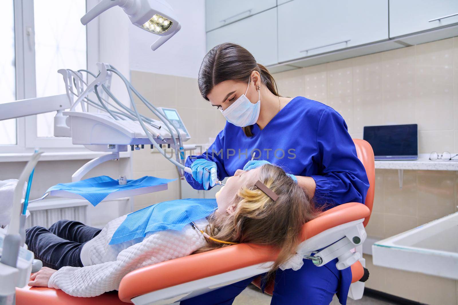 Female doctor dentist treats teeth to a child girl using anesthesia. Treatment, dentistry, children, health, dental care concept
