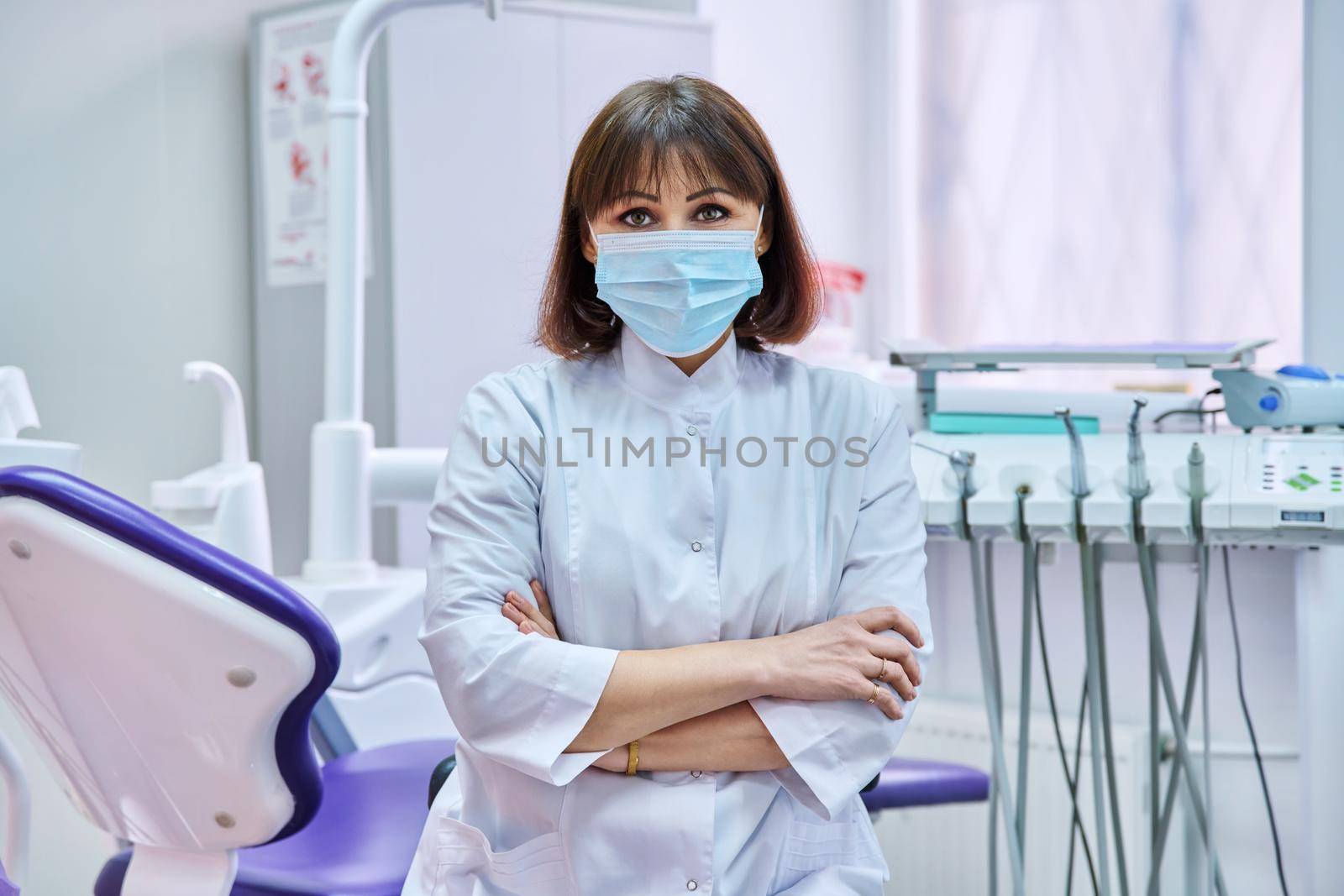 Portrait of confident female dentist doctor in office looking at camera by VH-studio