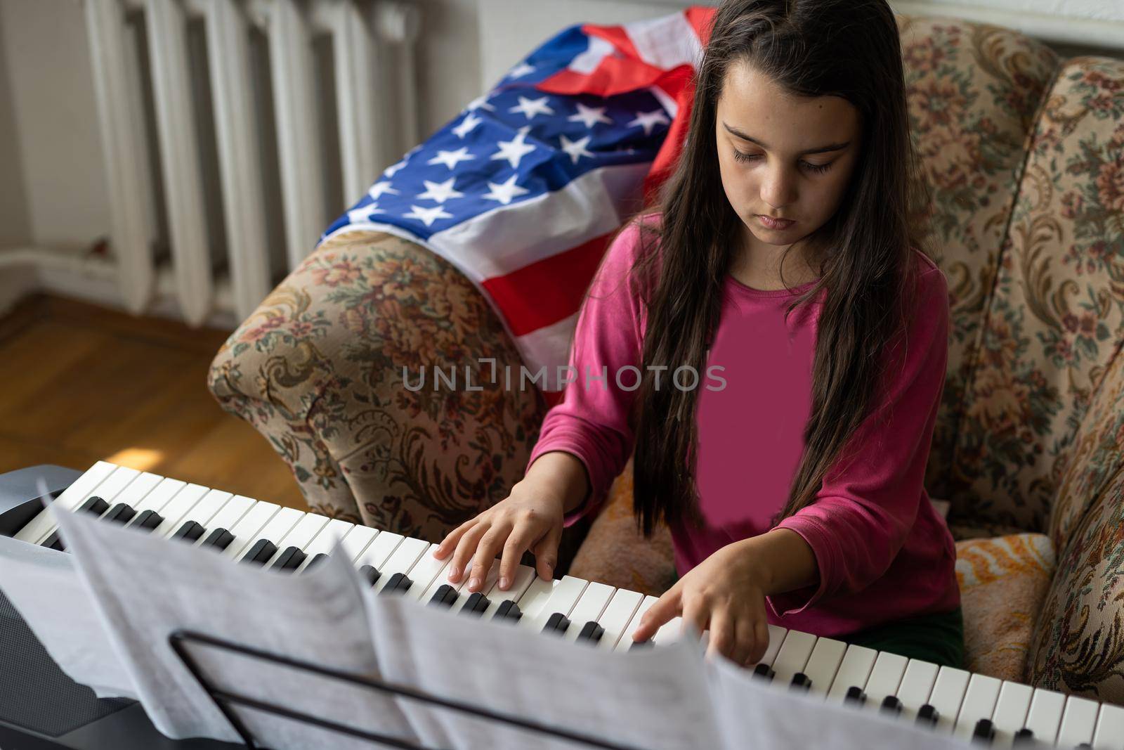 little brunette girl playing the piano with notes with flag of ukraine at home by Andelov13