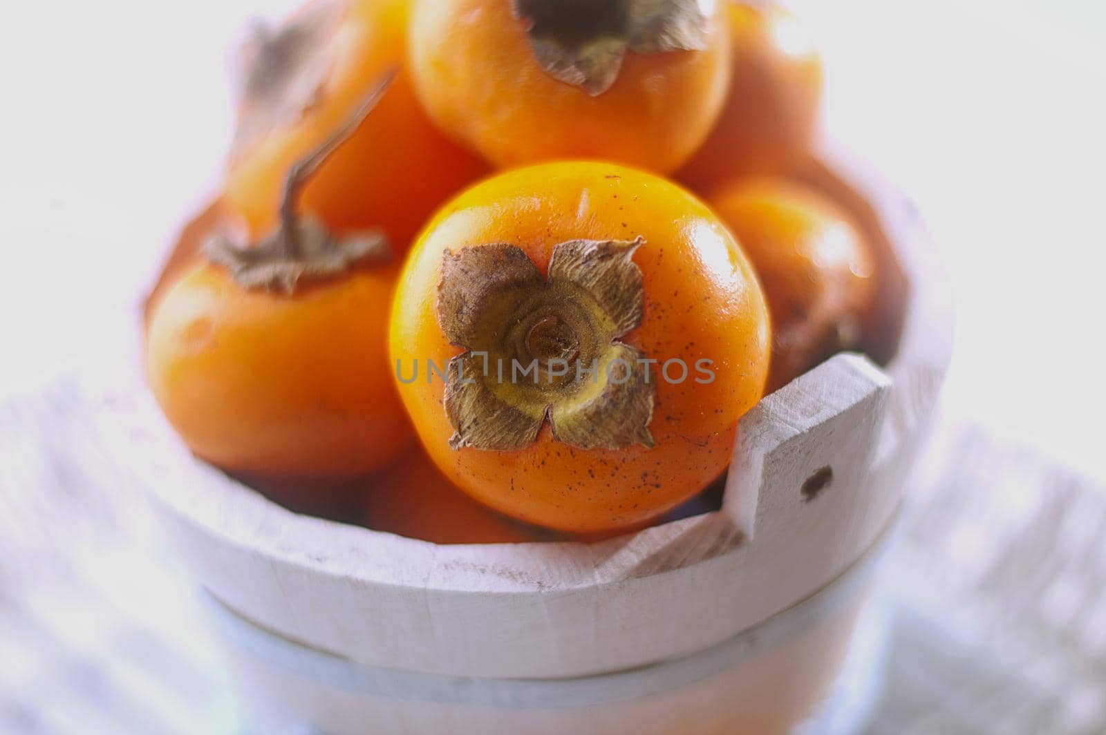 persimmons in a basket and scattered on the table. rustic style. High quality photo