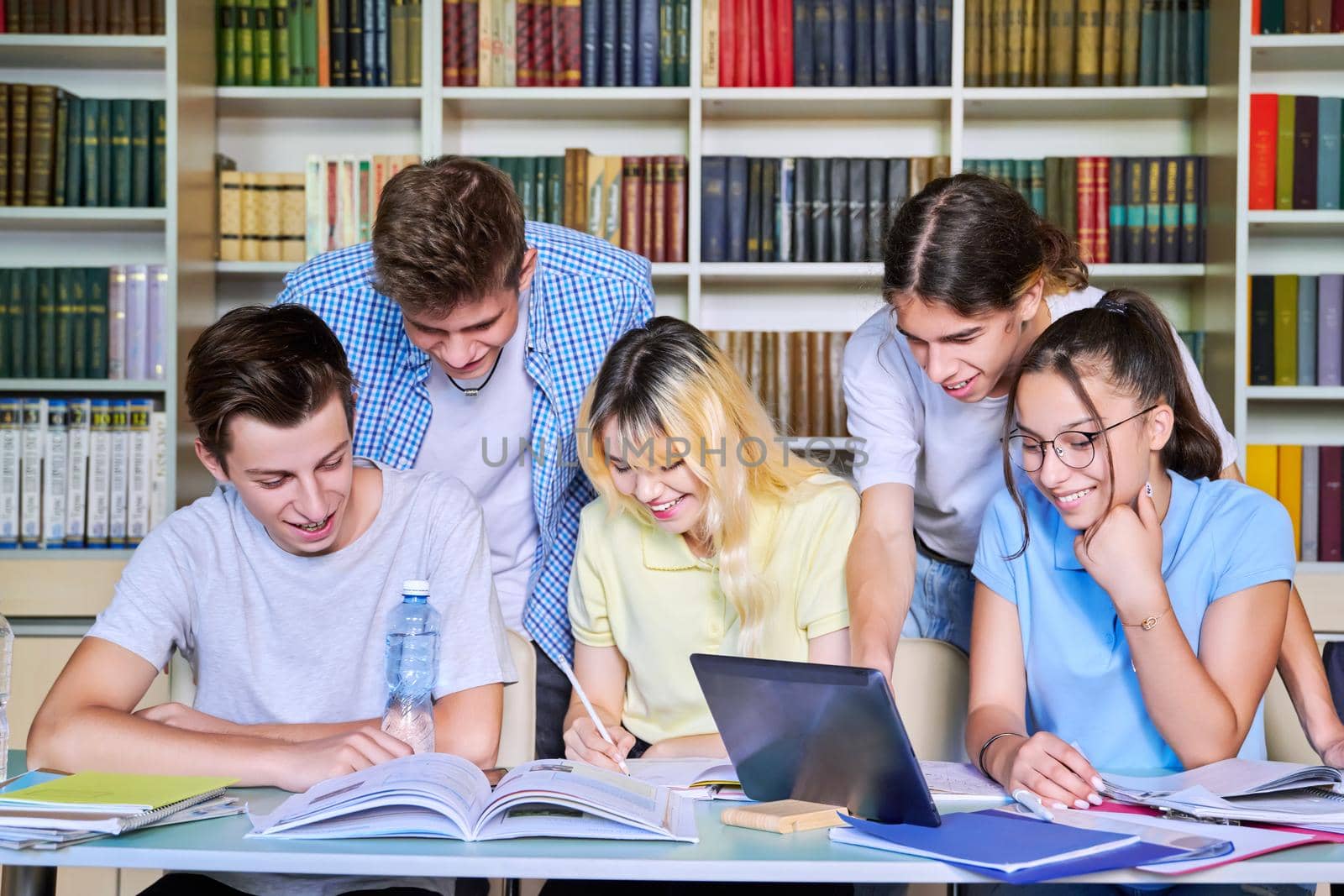 Group of teenage students study in library class. by VH-studio