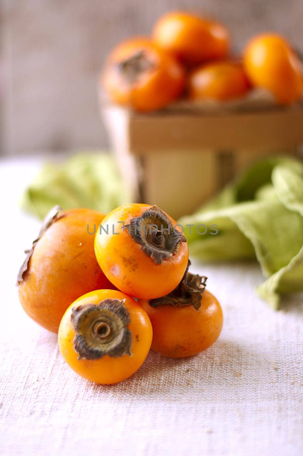 persimmons in a basket and scattered on the table. rustic style. High quality photo