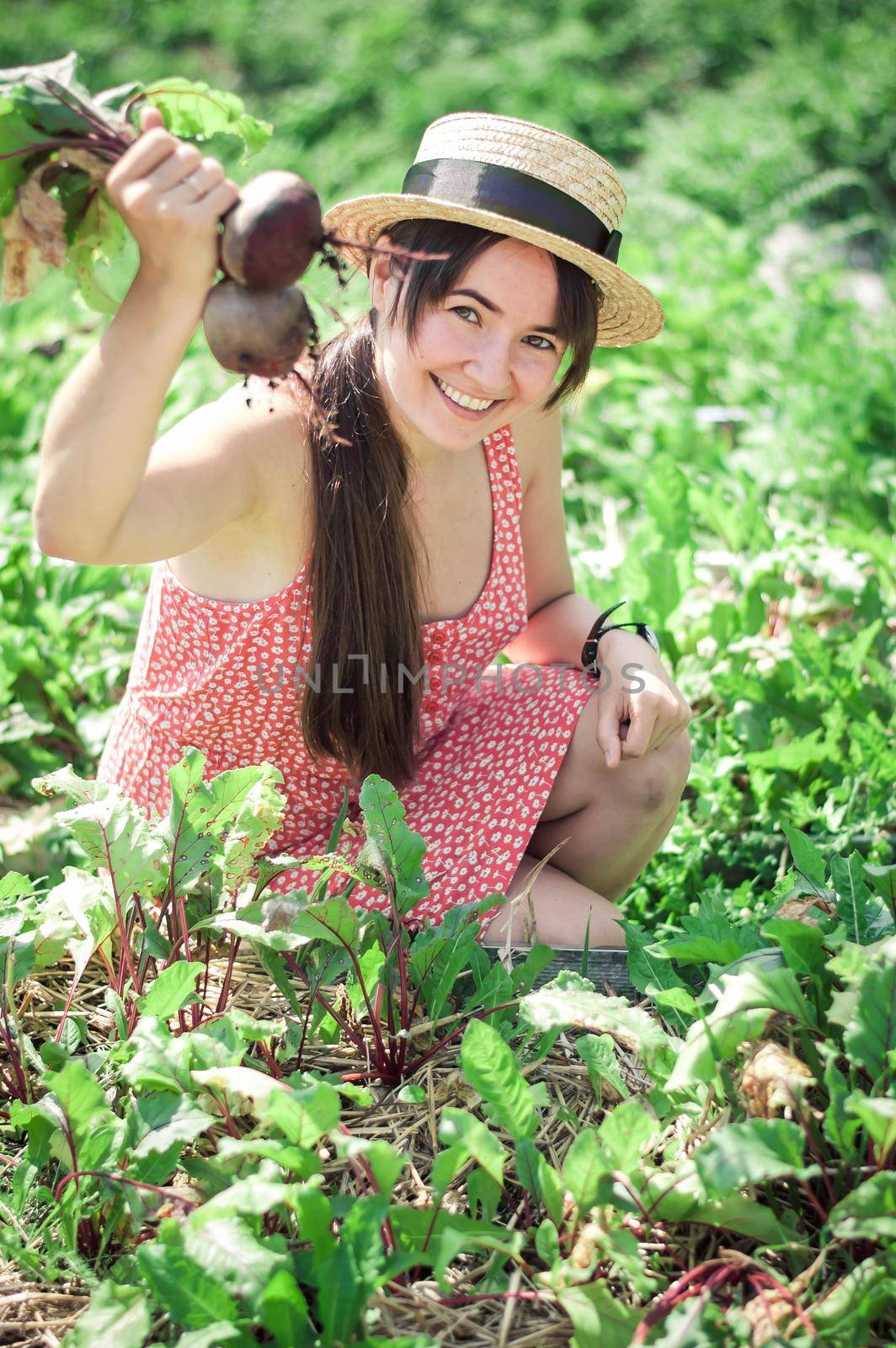 happy young woman working in permaculture garden . High quality photo