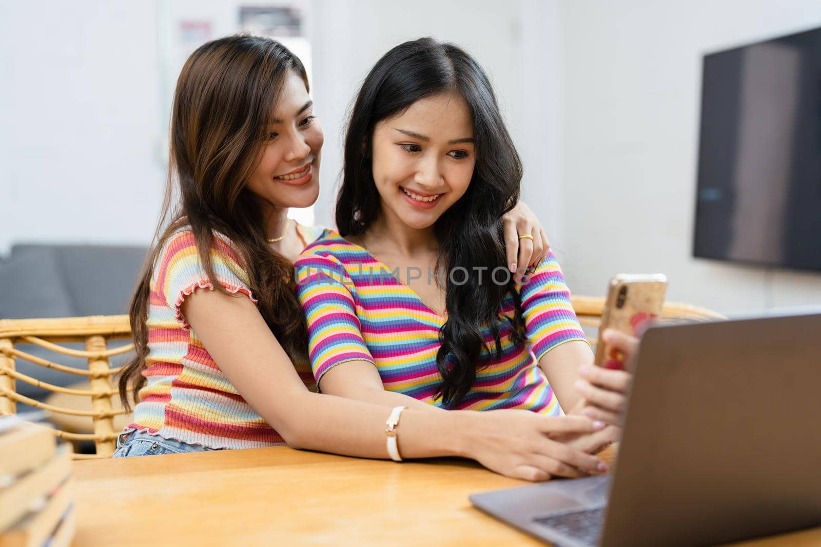 lgbtq, lgbt concept, homosexuality, portrait of two asian women posing happy together and loving each other while playing computer laptop by Manastrong