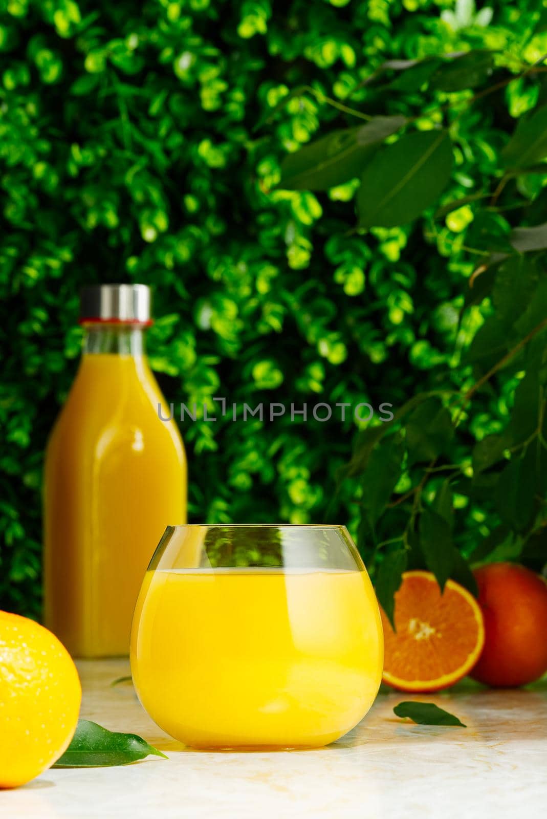 Glass of orange juice and orange juice bottle. Fresh tropical juice. by PhotoTime
