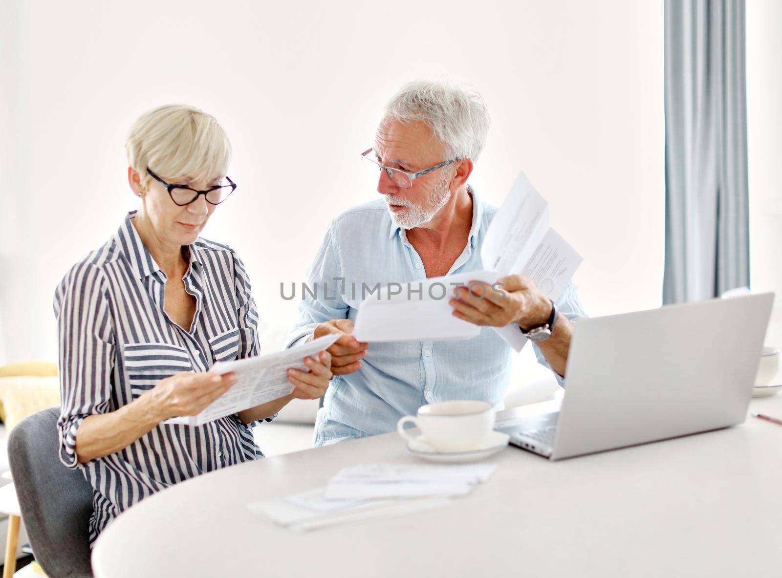 woman man finance senior retirement couple home bil document paperwork table paper tax by Picsfive