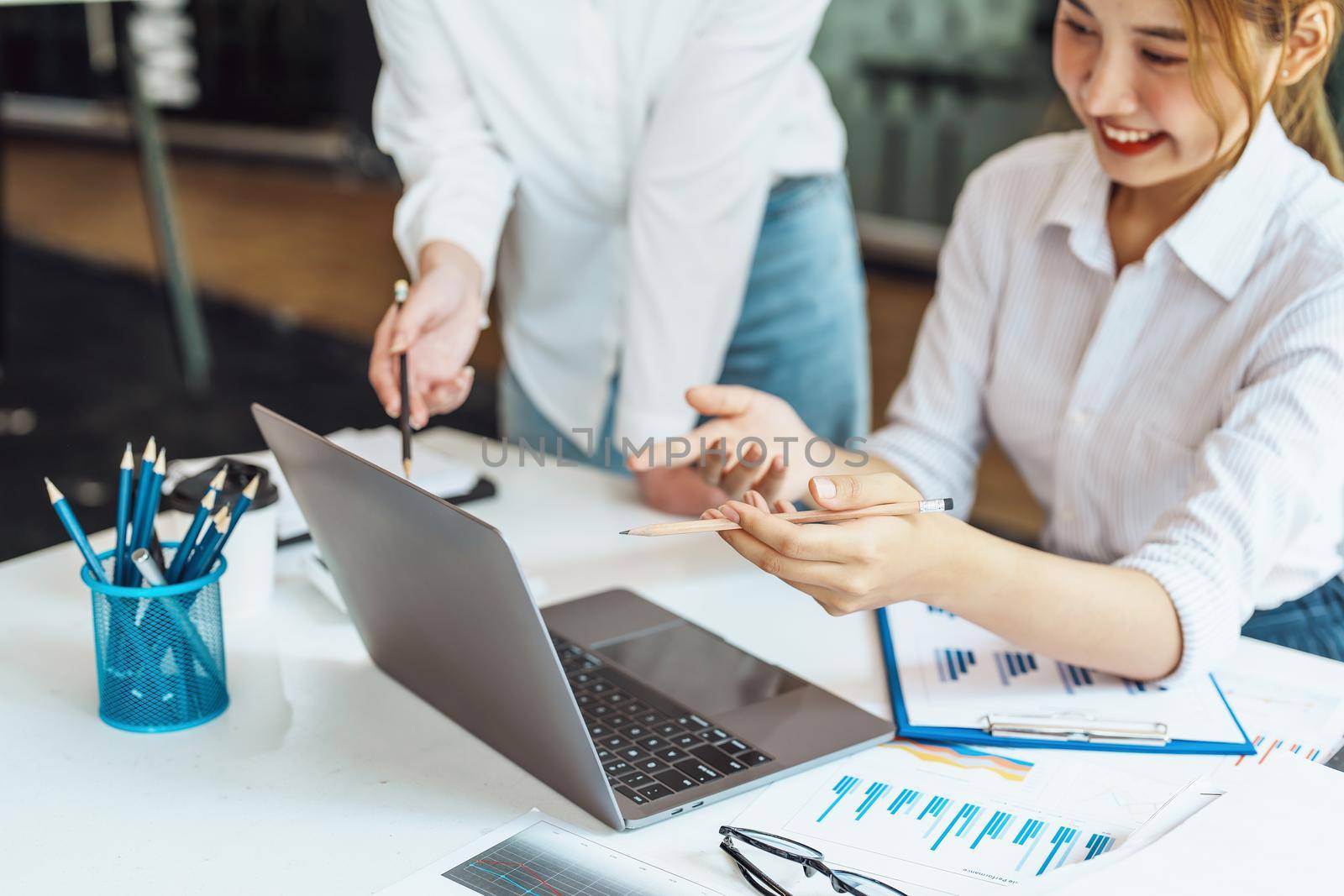 Negotiation, Analysis, Discussion, Asian woman economist and marketer using computer laptop to plan investments and financial to prevent risks and losses for the company.