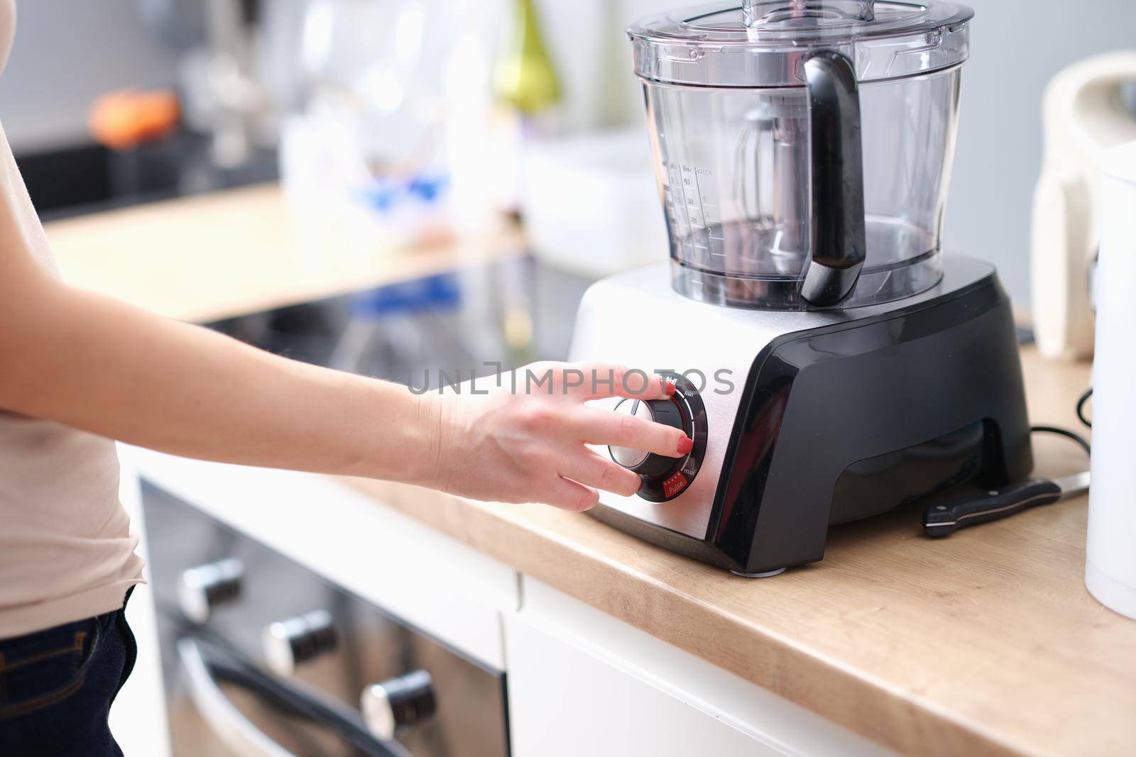 Woman turns on mixer for mixing products. food processor blender concept