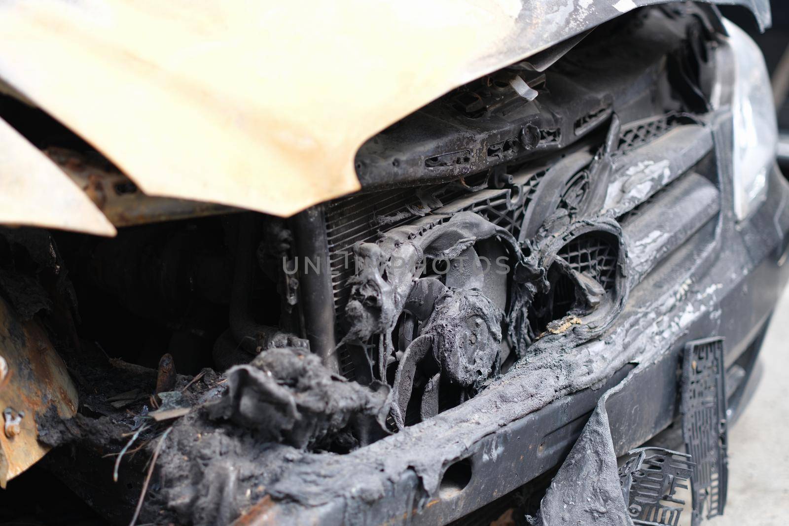 Broken and completely burned out car. Car arson or faulty electrical wiring cause fire concept
