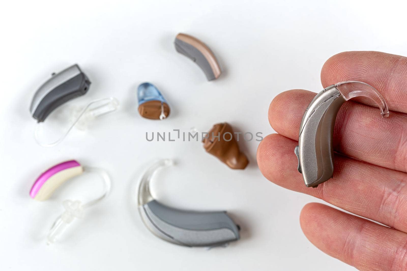 In-ear prosthesis on a finger, surrounded by other models.