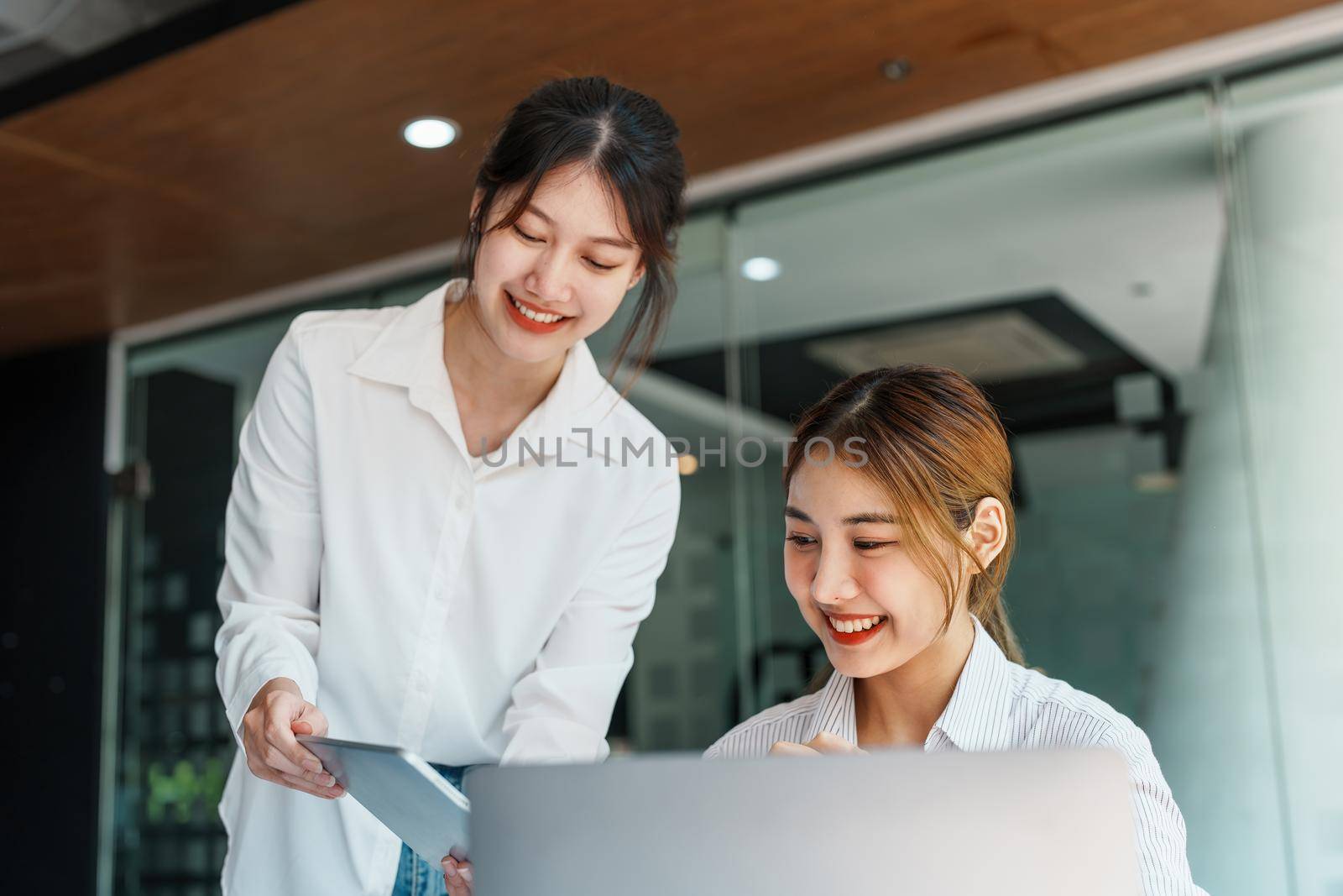 Negotiation, Analysis, Discussion, Portrait of an Asian woman economist and marketer using tablet computer to plan investments and financial to prevent risks and losses for the company.